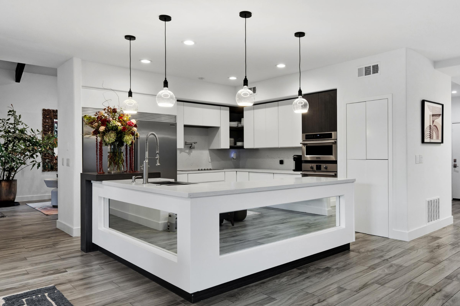 Kitchen with a square waterfall island and pendant lights
