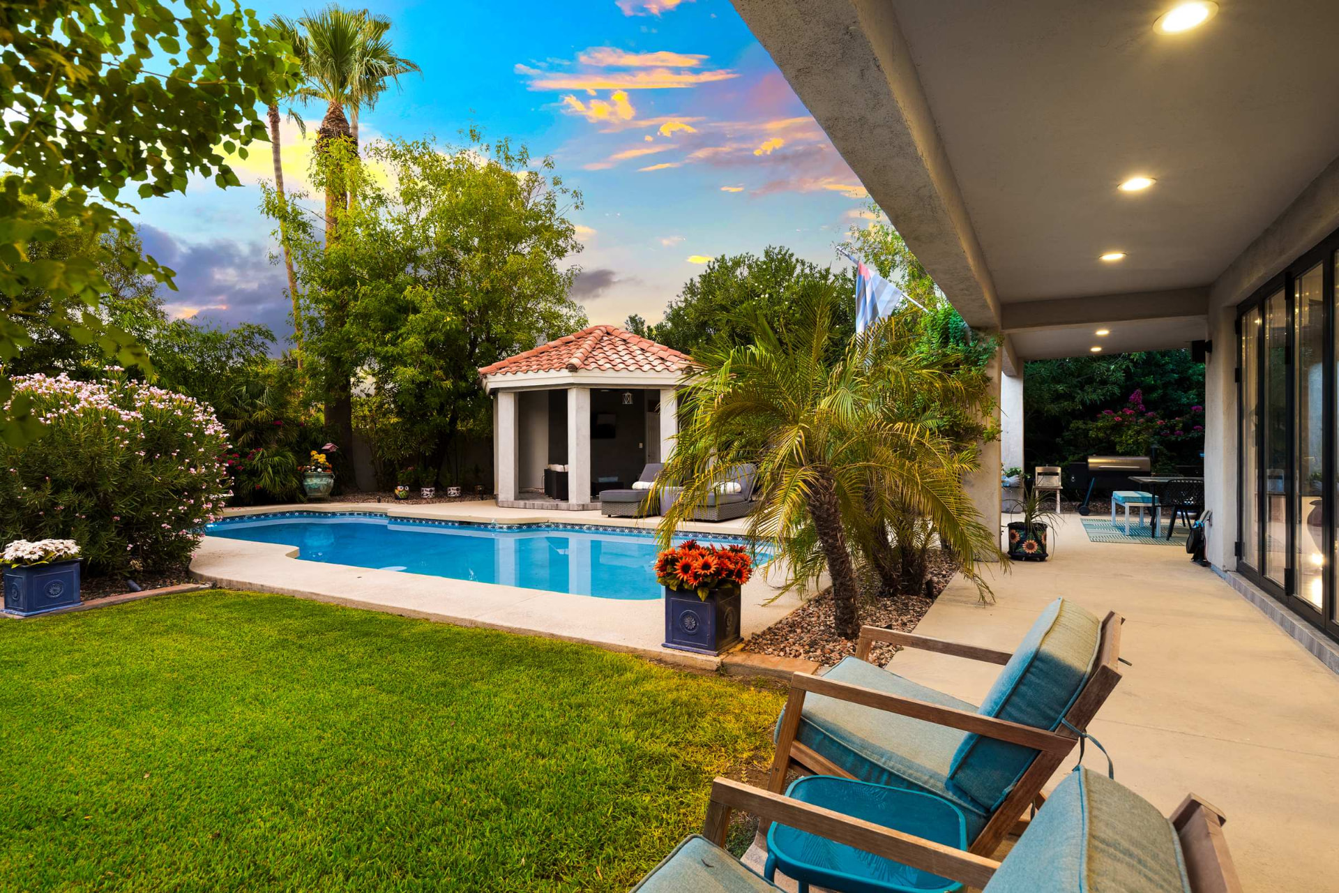 Covered patio looking across the lawn to the pool and pavilion