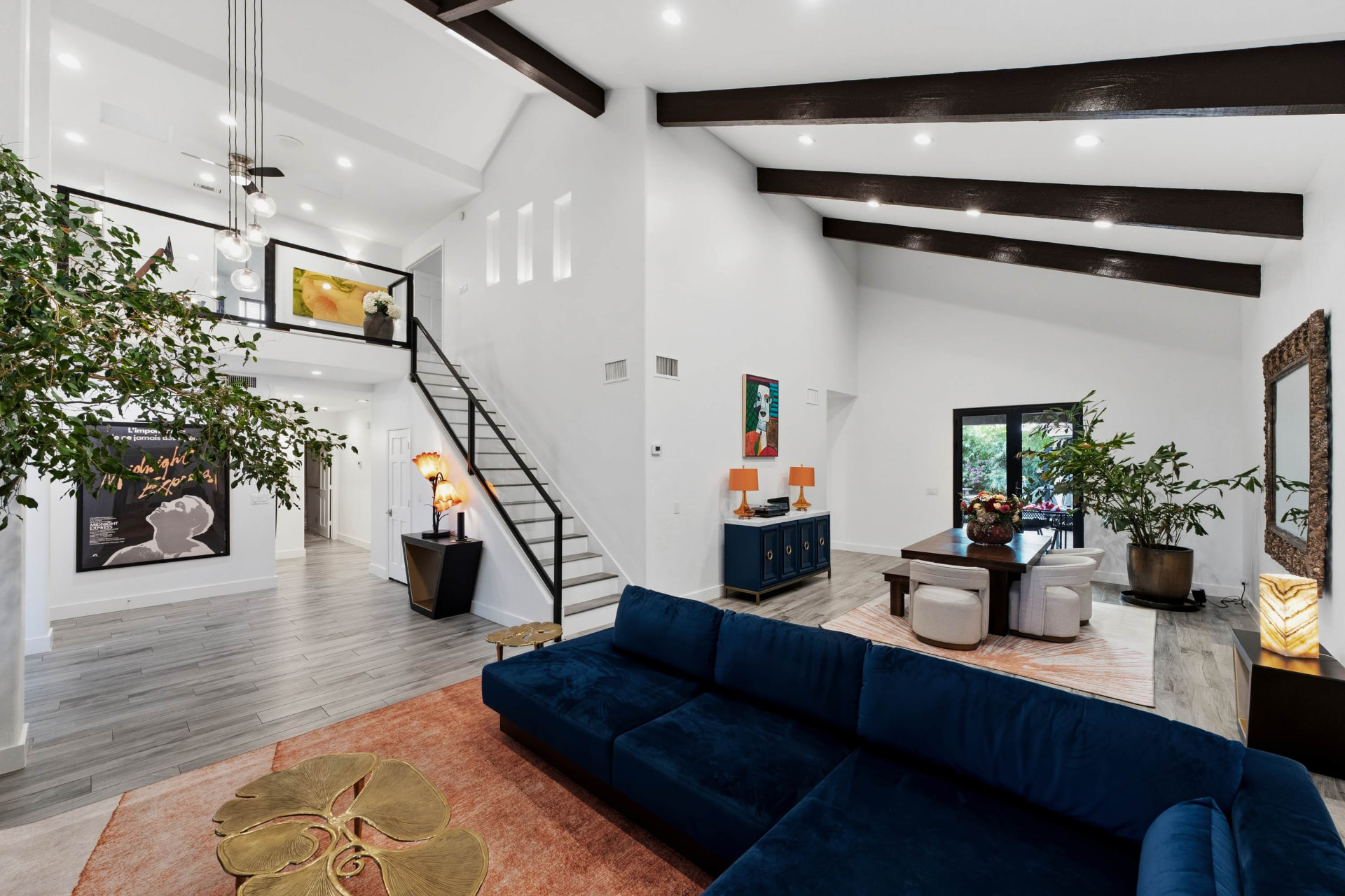Great room with beamed vaulted ceiling and open stair